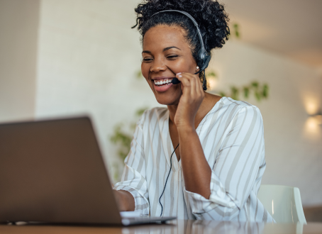 Friendly customer service representative assisting hospitality clients via laptop, providing hotel stock and supply support.
